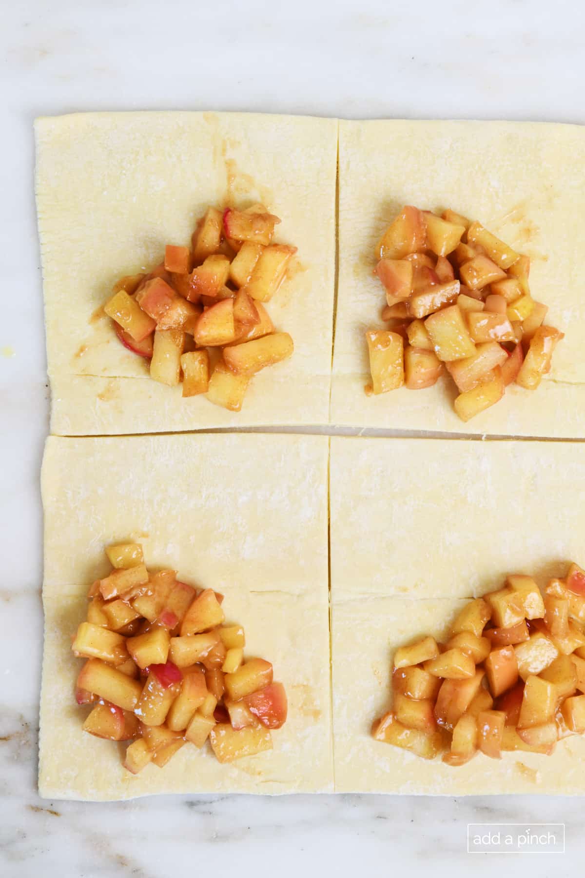 Rolled and cut puff pastry dough topped with apple filling.