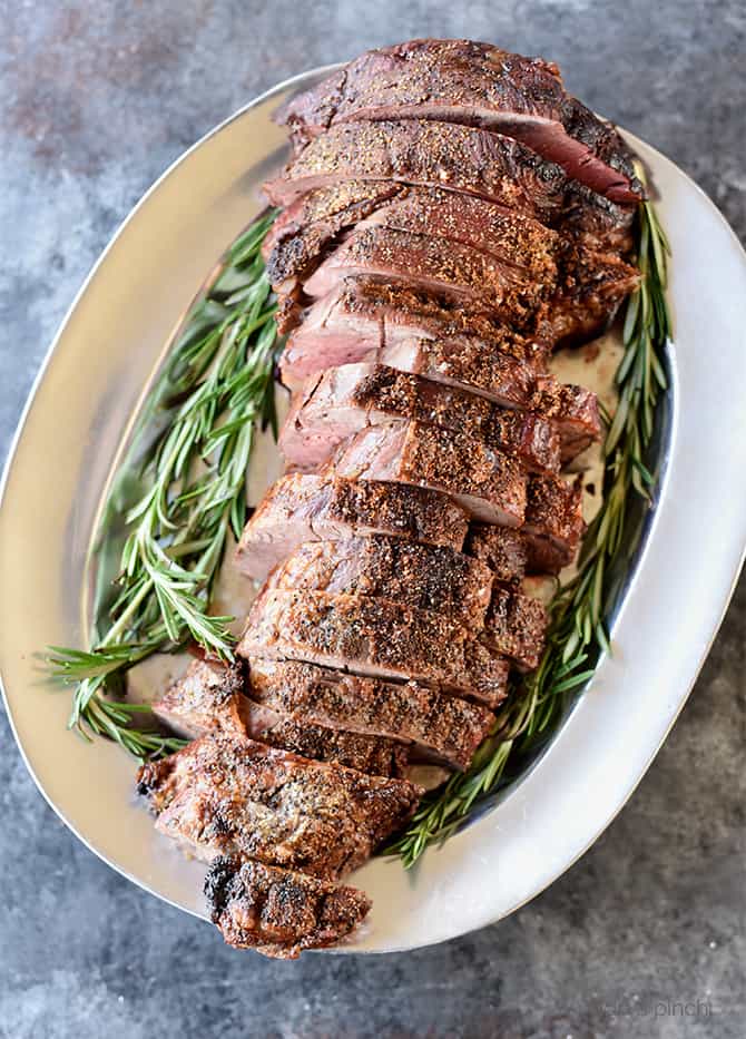 Overhead picture of sliced beef surrounded by rosemary.