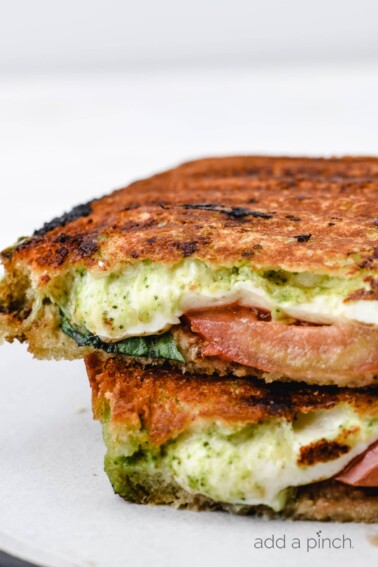 Caprese Grilled Cheese Sandwich Recipe - A delicious, gourmet grilled cheese made of sourdough, pesto, mozzarella, tomatoes, and fresh basil. // addapinch.com