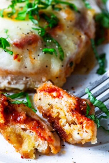 Image of bite of chicken parmesan on a fork.