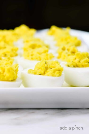 Deviled eggs make the perfect appetizer or side dish for family meals, parties, holidays, potlucks, picnics and more. This simple and classic deviled eggs recipe is a family favorite! // addapinch.com