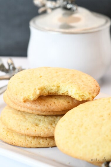 Photograph of stack of teacake cookies on a white platter. // addapinch.com