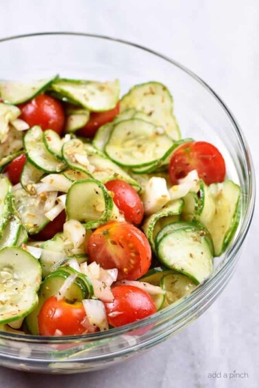 Cucumber Tomato Salad Recipe - A quick and easy summer staple, this cucumber and tomato salad goes well with fish, chicken, pork, or a plate filled with veggies! Add in onions too if you like! // addapinch.com