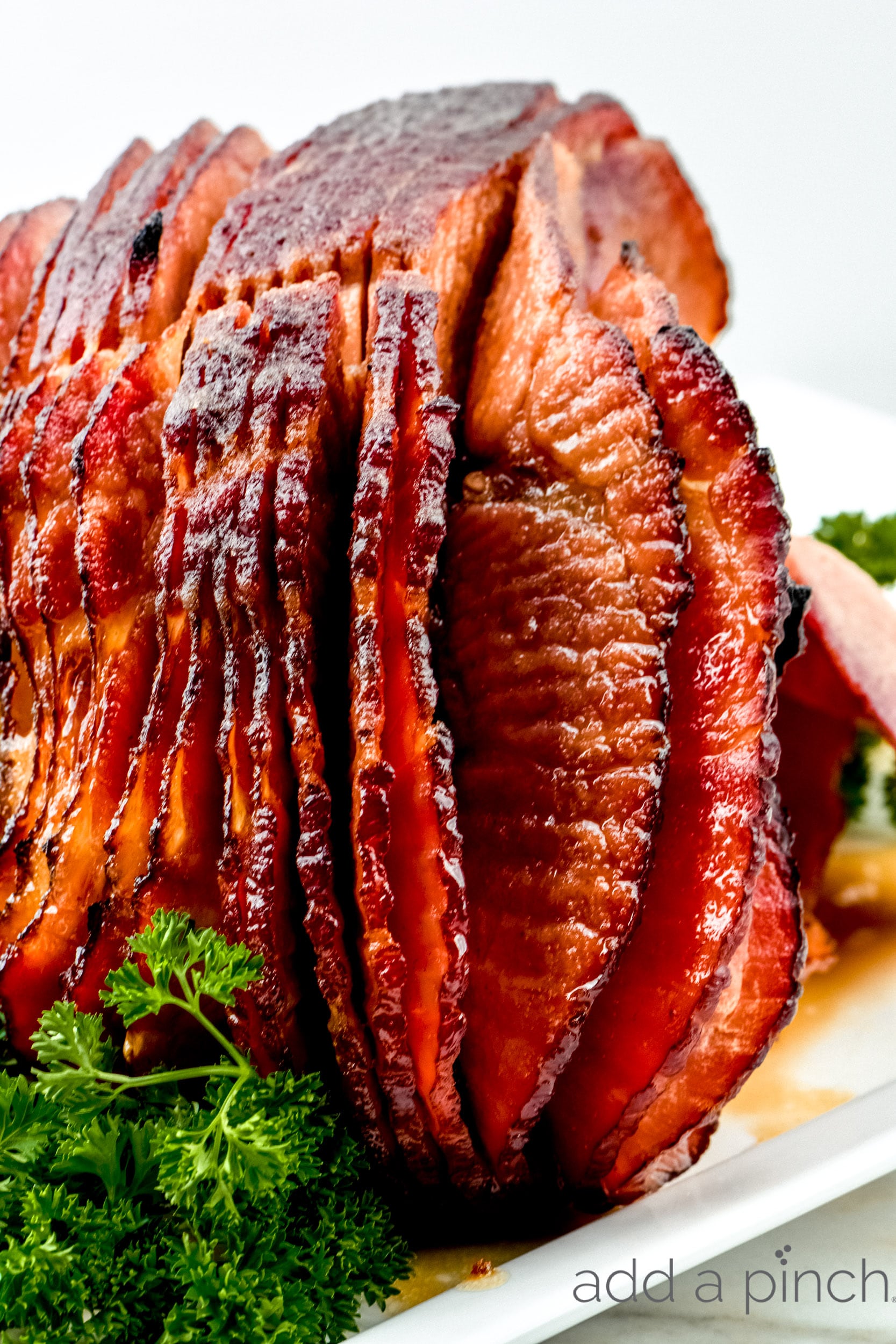 Cola Glazed Ham Recipe 
 on serving platter with garnish.