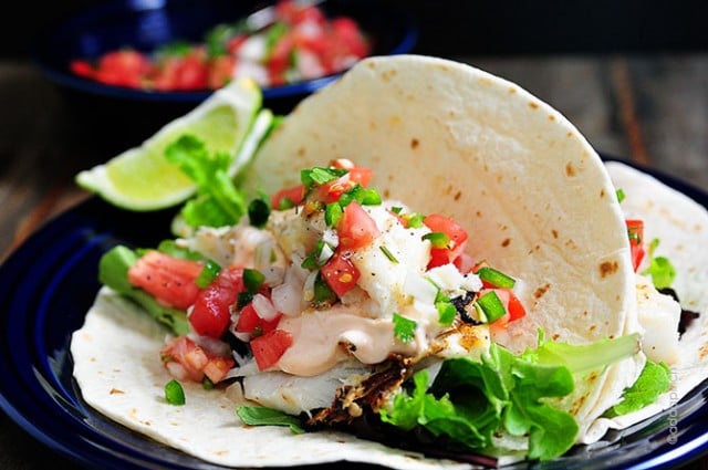 Fish tacos served with a lime wedge - addapinch.com