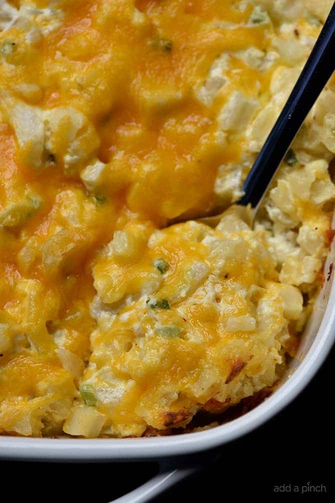 Baked potato casserole in a baking dish with serving spoon.