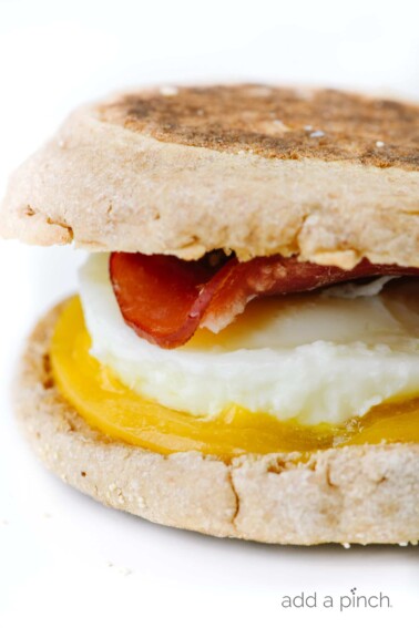 Homemade Egg McMuffin in closeup shot - with English muffin, cheese, egg, and Canadian bacon // addapinch.com