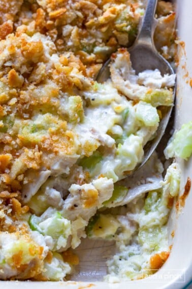 Hot chicken salad baked in a white baking dish.