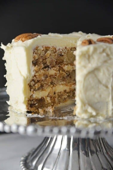 Photo of Hummingbird Cake ion a pewter cake plate, topped with a cream cheese frosting.