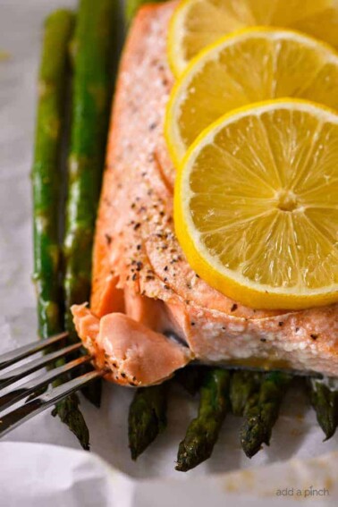 Lemon Garlic Salmon and Asparagus Parchment Packet Recipe - This quick and easy recipe comes together in a snap and is ready and on the table in 15 minutes! // addapinch.com