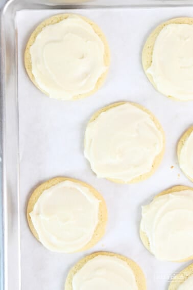 Frosted Lofthouse Cookies on a parchment lined baking sheet.