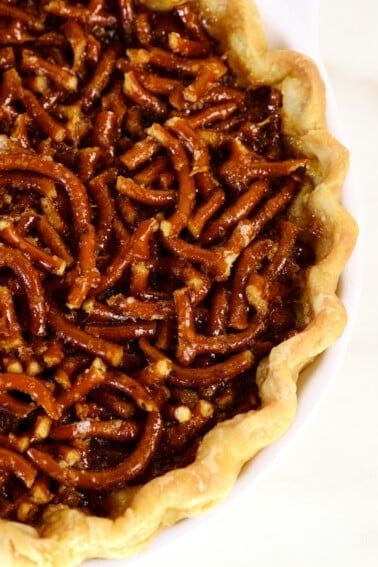 Mock pecan pie in a pie plate on a white surface.