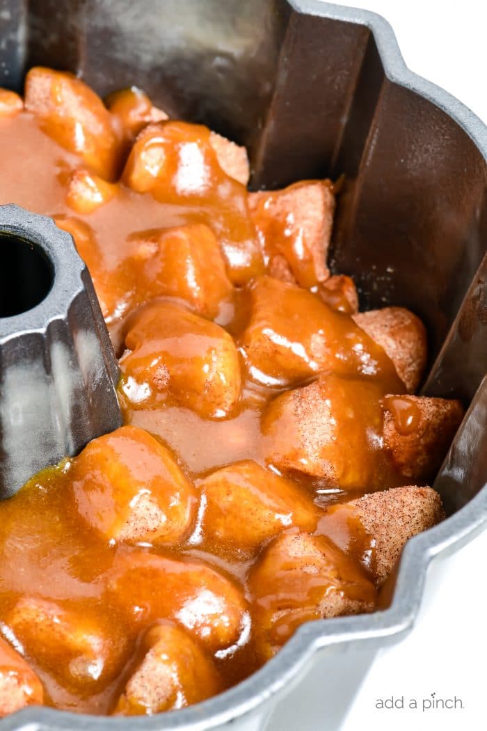 Photograph of caramel topped monkey bread in a bundt pan that is ready to be baked.