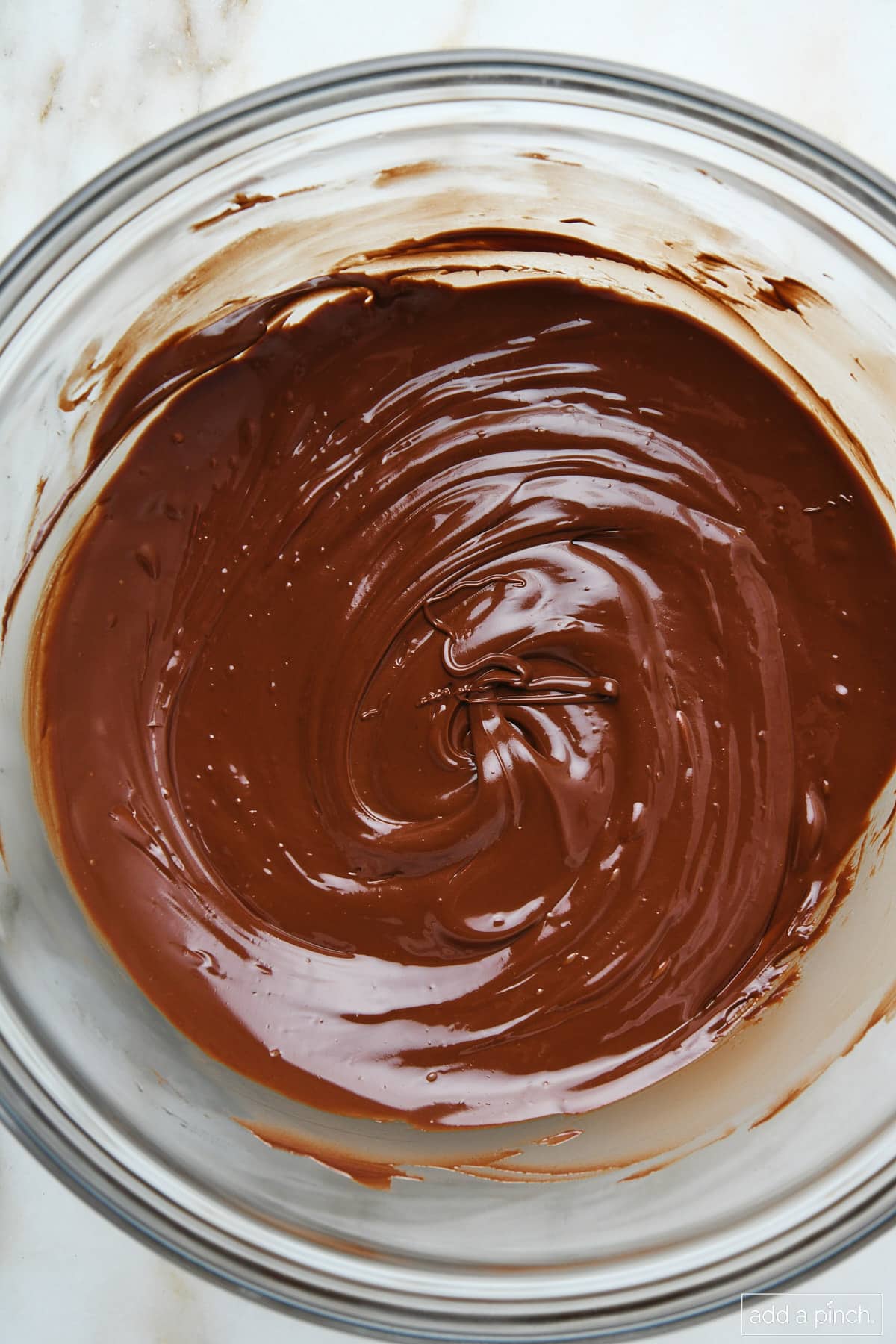 Melted chocolate in a glass mixing bowl.