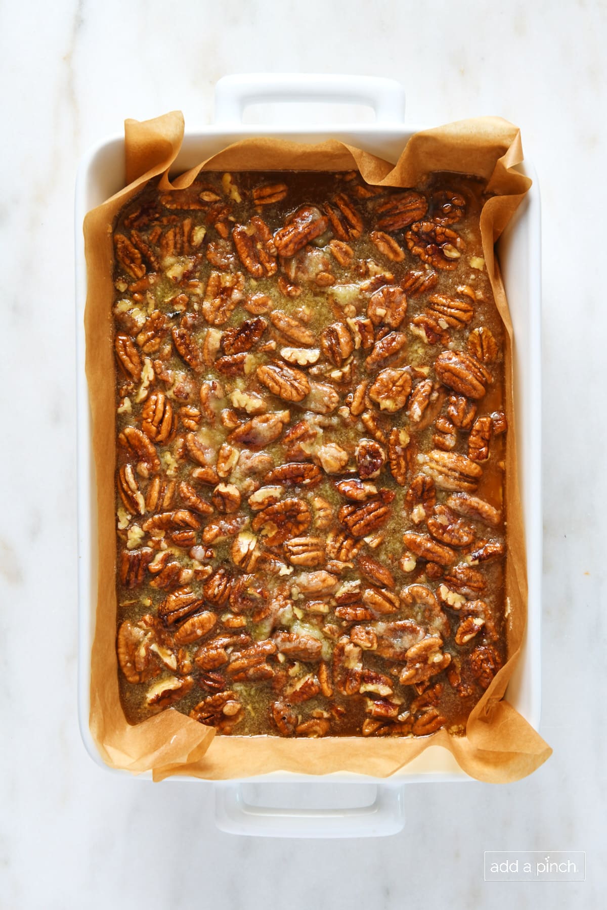 Unbaked pecan pie bars in a baking dish.