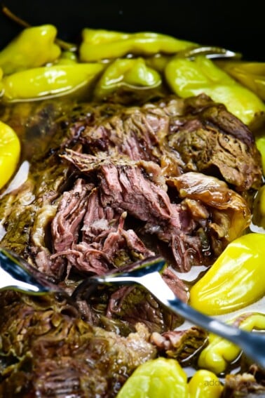 Photograph of Mississippi Roast with pepperoncini peppers in a slow cooker.