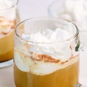 Glass mugs with hot pumpkin spice latte topped with whipped cream.