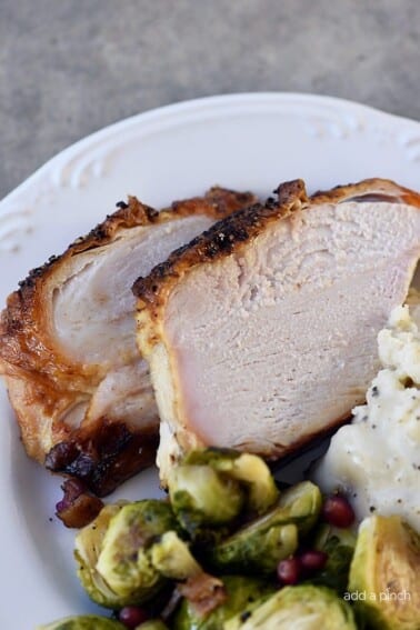 Photo of turkey slices, brussels sprouts and mashed potatoes on a white plate.