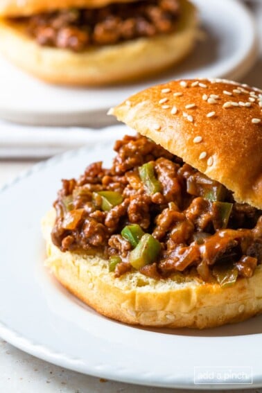 Sloppy Joe on a hamburger bun on a white plate.