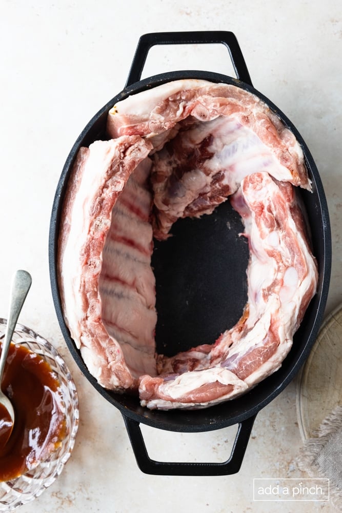 Rack of ribs arranged in a slow cooker.