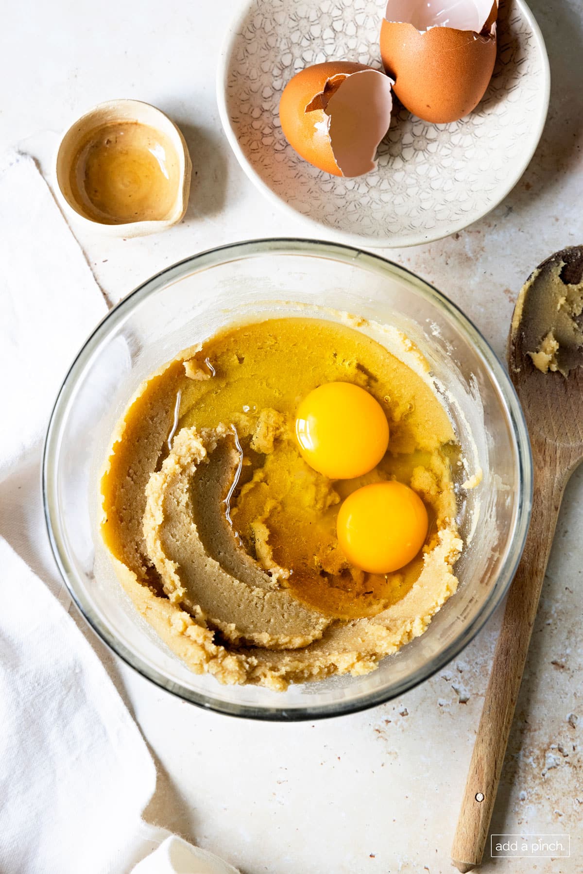 Image of bowl with creamed butter and sugar with eggs and vanilla extract.