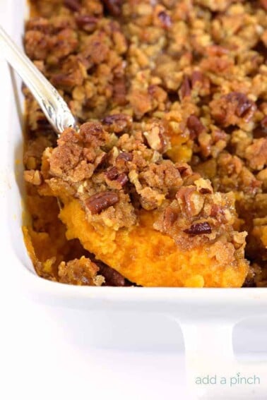 Sweet Potato Casserole topped with pecan streusel in white baking dish.