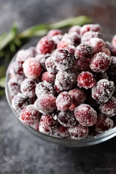 Sugared Cranberries Recipe - These sparkly sugared cranberries come together quickly and easily with just two simple ingredients! Beautiful as garnish for cakes, cookies, cocktails, or to serve as a sweet, yet tart treat! // addapinch.com