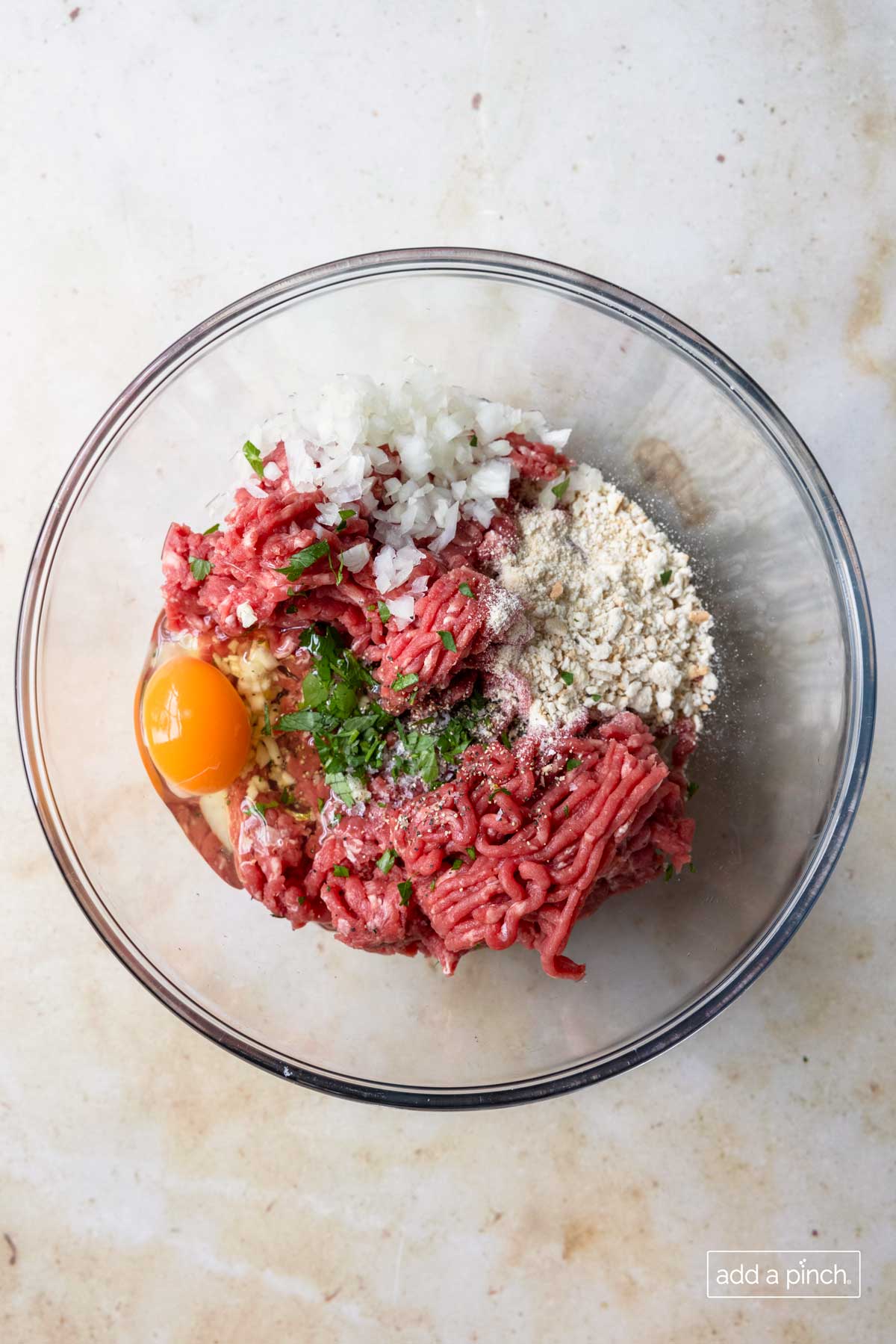 Ingredients for Swedish Meatballs in a glass bowl ready to be combined.