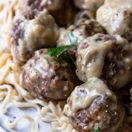 Photo of swedish meatballs served on a bed of noodles.