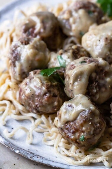 Photo of swedish meatballs served on a bed of noodles.