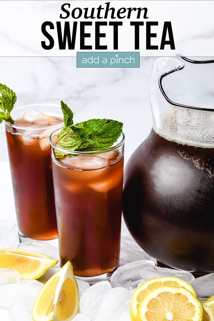 Southern Sweet Tea in a glass pitcher and two glasses with ice and garnished with mint and lemon - with text - addapinch.com