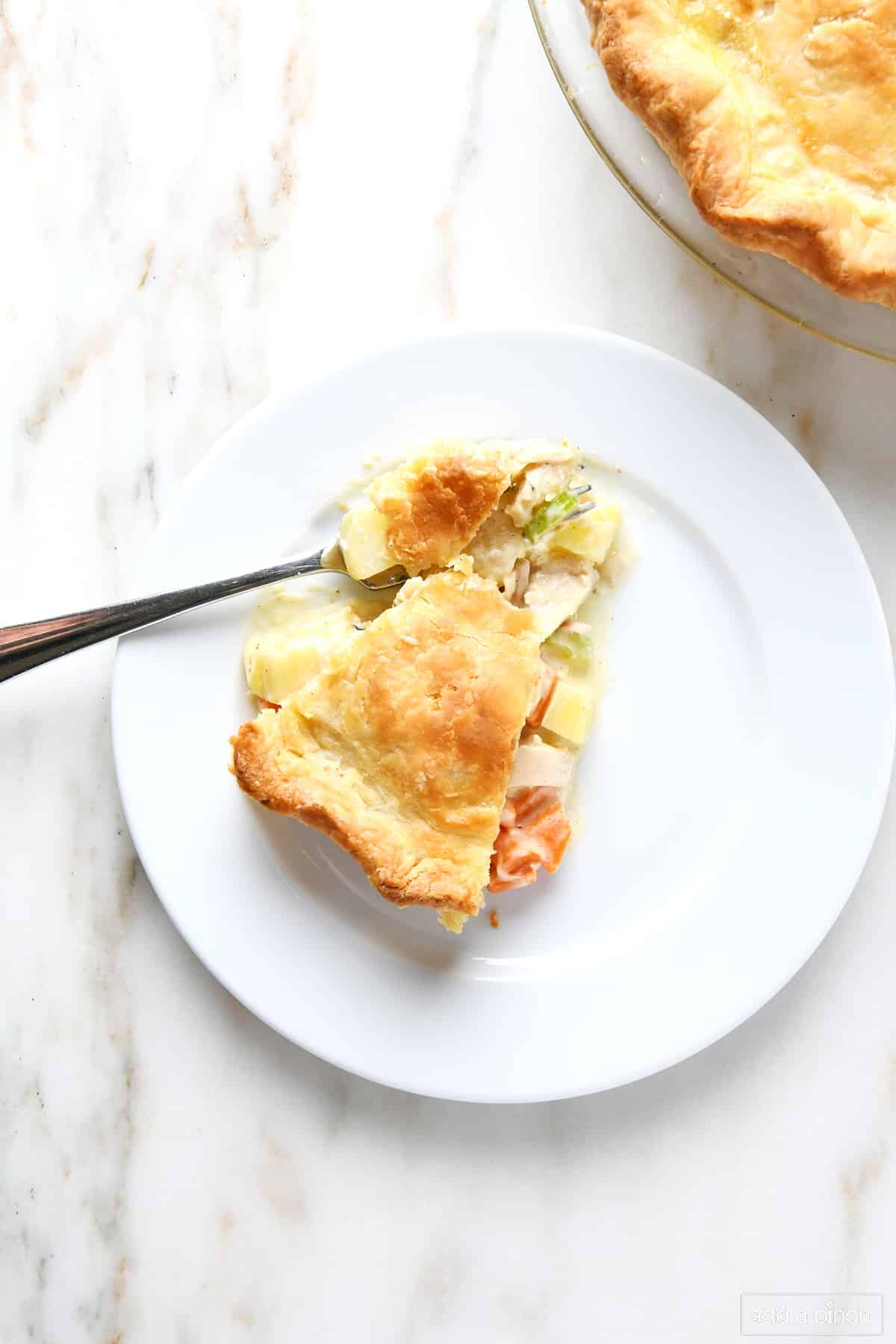 Slice of turkey pot pie on marble countertop.