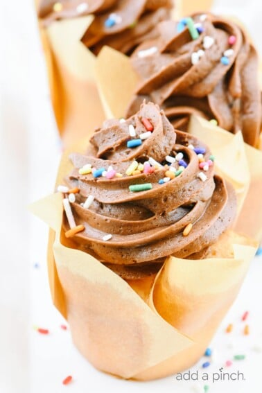 An easy recipe for vanilla cupcakes topped with a delicious chocolate buttercream frosting. They make the perfect cupcakes for every occasion! // addapinch.com